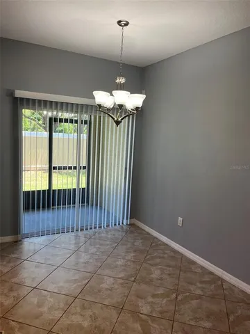 a view of a room with a chandelier and large windows