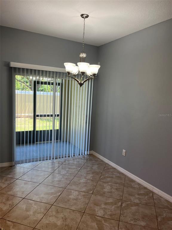 1242 Acadia Harbor Place Brandon, FL 33511 - Photo 9 of 28 a view of a room with a chandelier and large windows