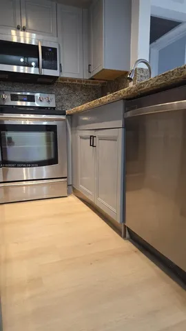 a kitchen with granite countertop a stove and a microwave