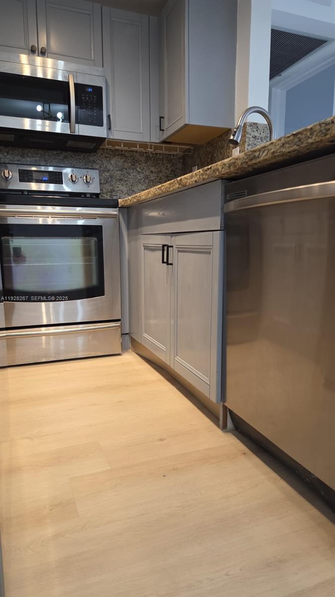 a kitchen with granite countertop a stove and a microwave