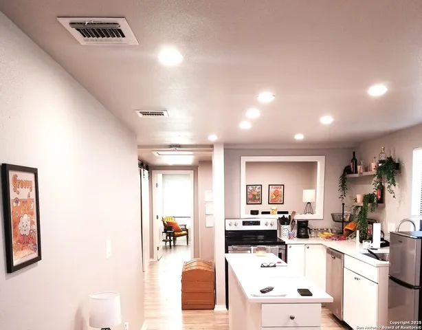a room with stainless steel appliances kitchen island granite countertop furniture and a view of living room