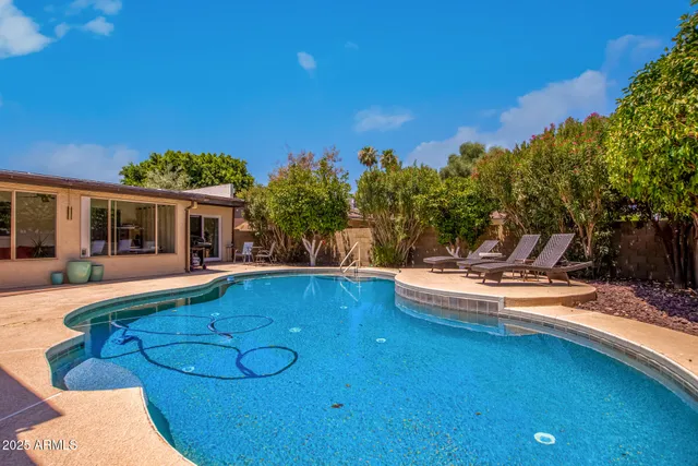 a view of a house with swimming pool and sitting area