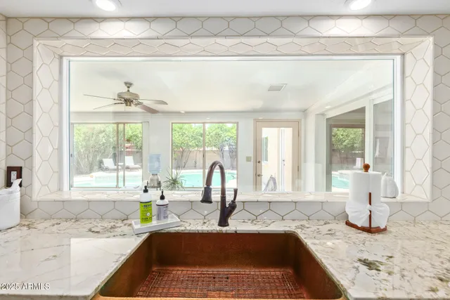 a kitchen with a granite countertop sink and window