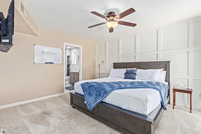 a bedroom with a large bed and a chandelier