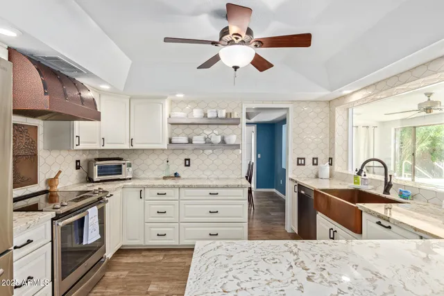a kitchen with stainless steel appliances granite countertop a sink a stove and cabinets