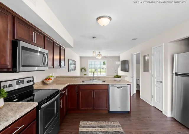 a kitchen with stainless steel appliances granite countertop a stove top oven a sink dishwasher a refrigerator and cabinets with wooden floor