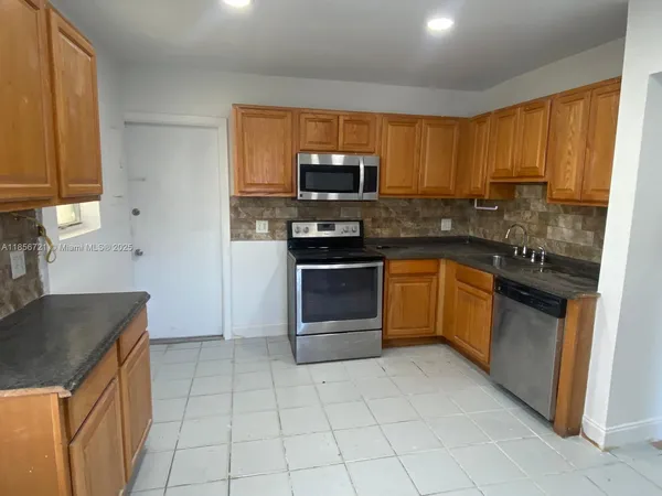 a kitchen with stainless steel appliances granite countertop a stove a sink and a refrigerator
