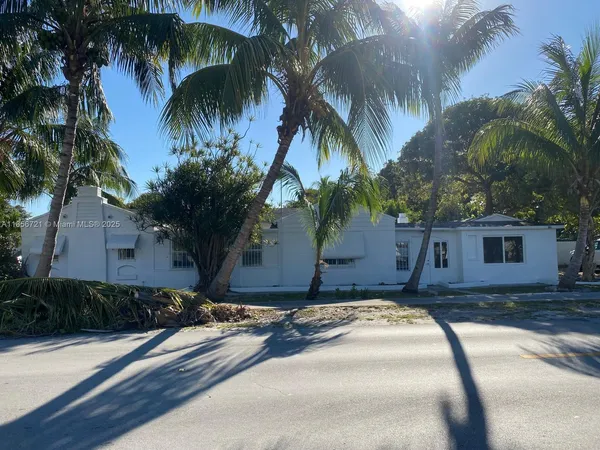 a house with a yard and palm trees