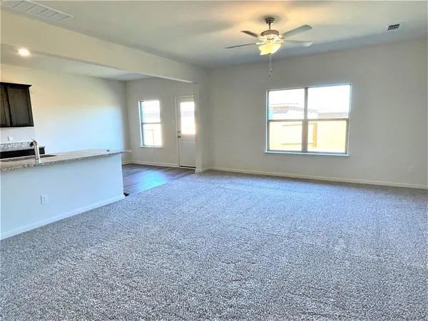 an empty room with windows and fan