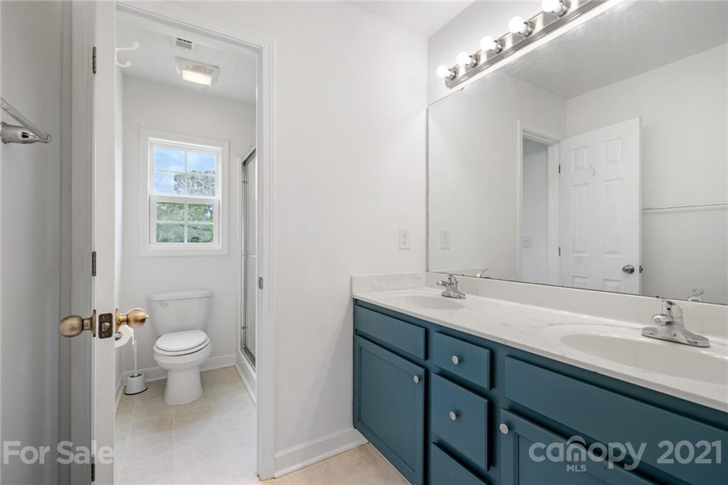 1174 South Rutherford Street Blacksburg, SC 29702 - Photo 29 of 40 a bathroom with a granite countertop sink a toilet and a mirror
