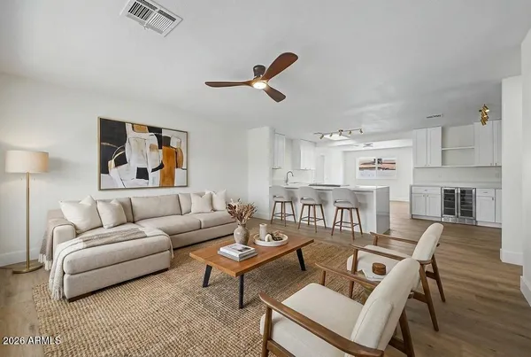 a living room with furniture kitchen view and a window