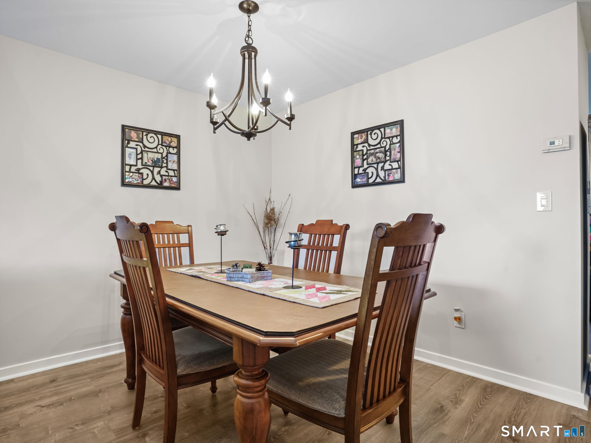71 Aiken Street, Unit C8 Norwalk, CT 06851 - Photo 7 of 29 a view of a dining room with furniture a chandelier and wooden floor