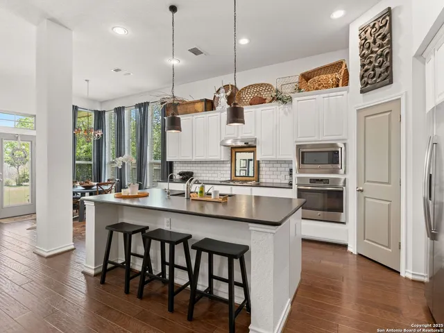 a kitchen with stainless steel appliances granite countertop a sink a stove and a refrigerator
