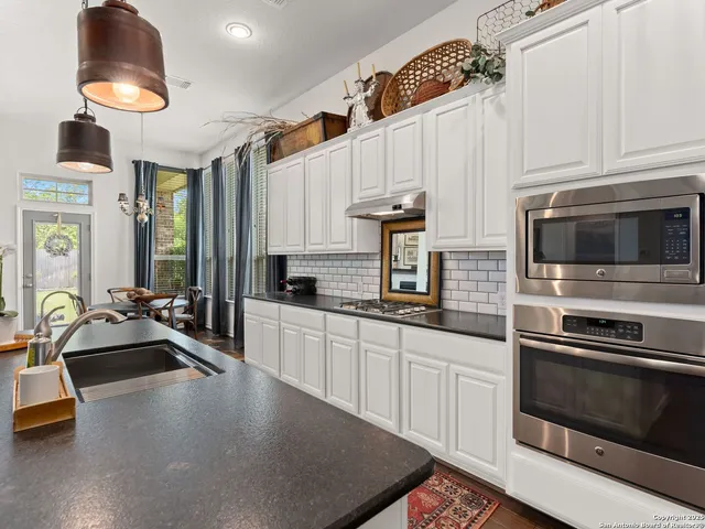 a kitchen with stainless steel appliances a sink a stove and cabinets