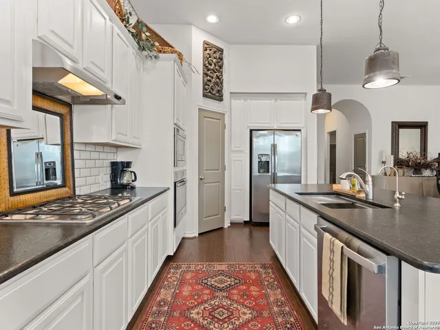 a kitchen with stainless steel appliances granite countertop a sink and cabinets