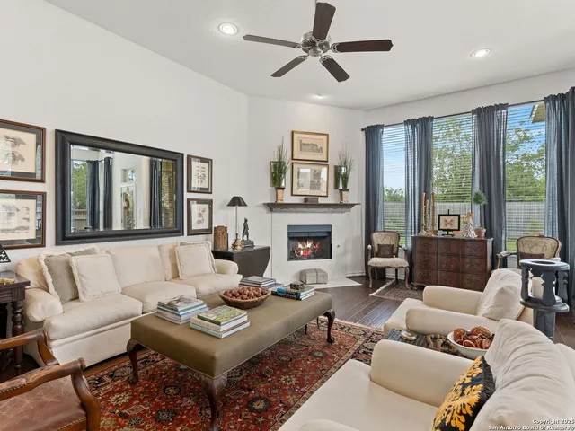 a living room with furniture a large window and a fireplace