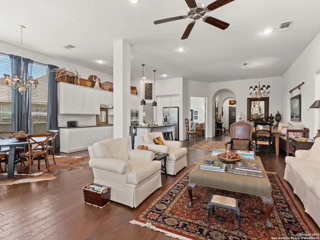 a living room with furniture kitchen view and a large window