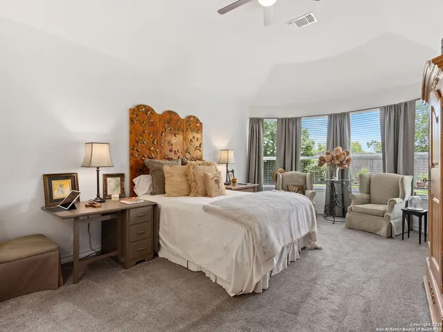 a spacious bedroom with a bed and a chandelier