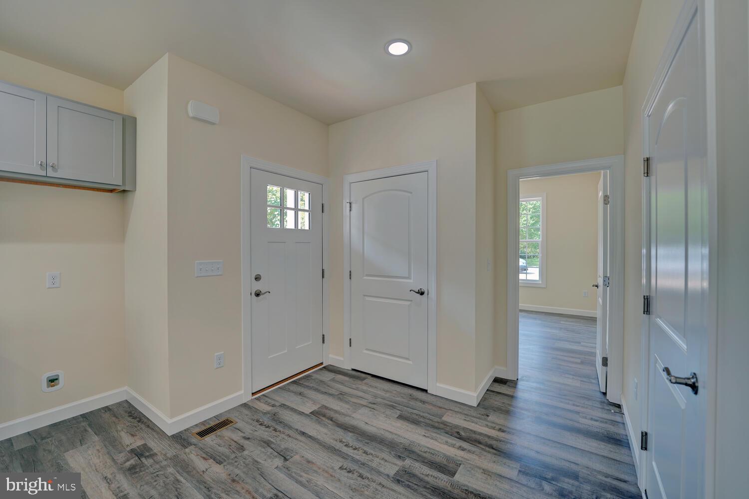29 Mapledale Road Dover, DE 19904 - Photo 5 of 65 a view of an empty room with wooden floor and a mirror