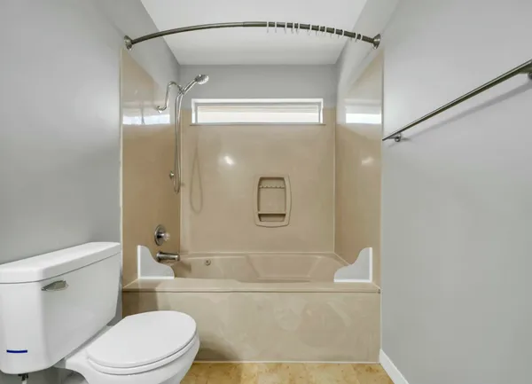 a bathroom with a granite countertop mirror vanity and toilet