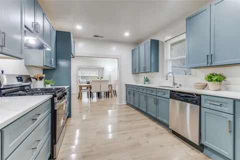 a kitchen with stainless steel appliances granite countertop a sink a stove and a refrigerator