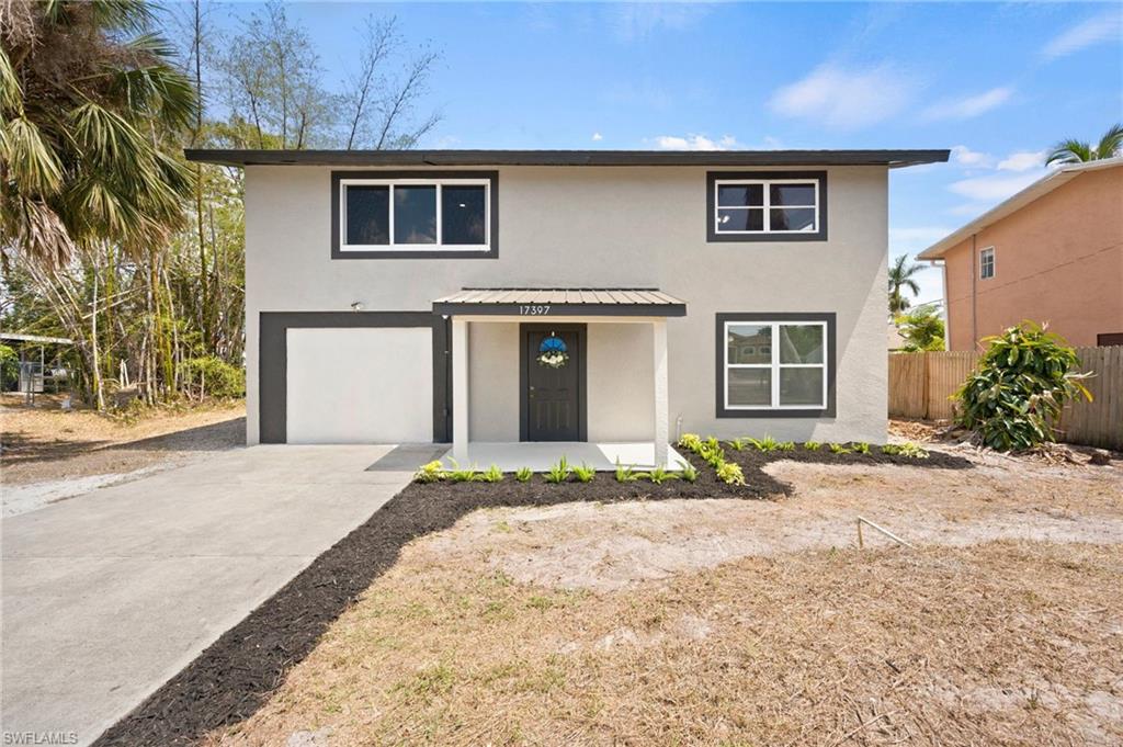 17397 Lee Road Fort Myers, FL 33967 - Photo 2 of 22 a front view of a house with a yard and garage