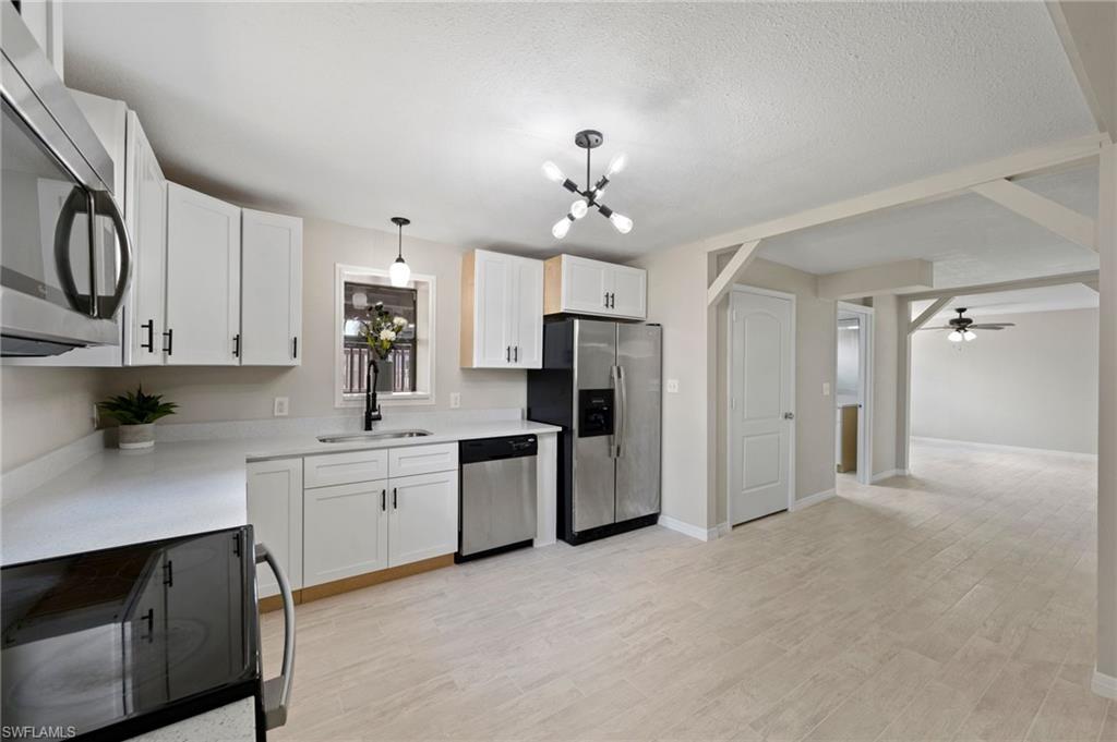 17397 Lee Road Fort Myers, FL 33967 - Photo 4 of 22 a large kitchen with cabinets and stainless steel appliances