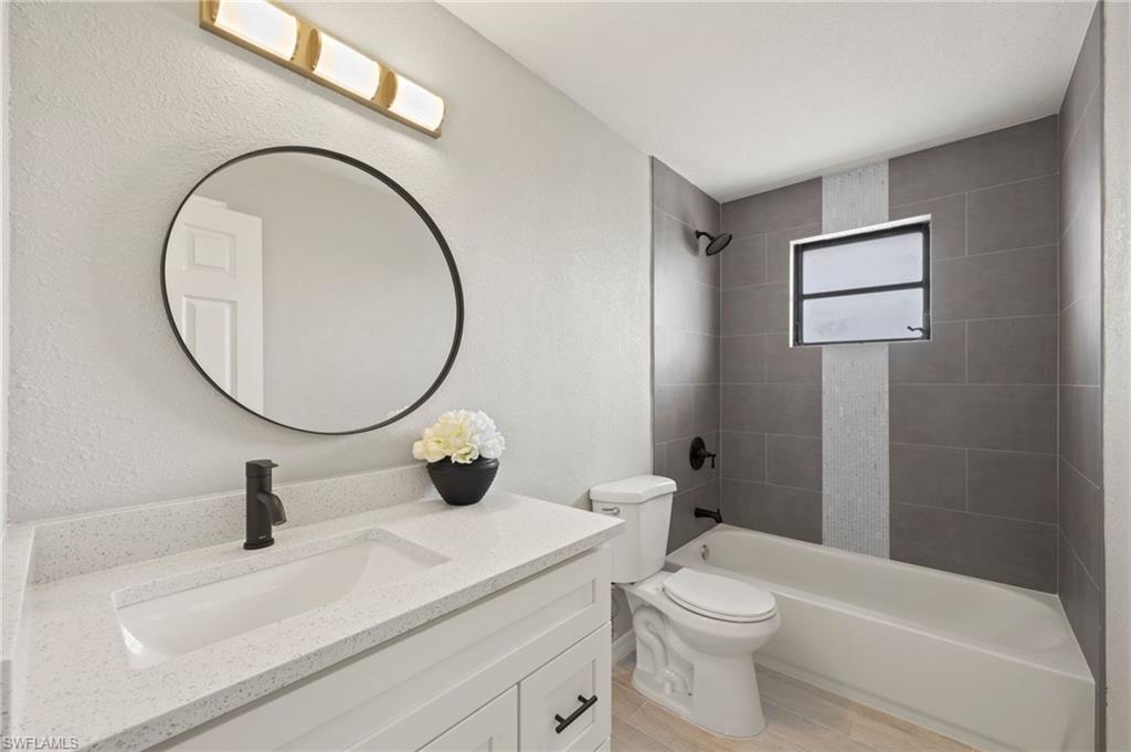 17397 Lee Road Fort Myers, FL 33967 - Photo 5 of 22 a bathroom with a sink a toilet and a mirror