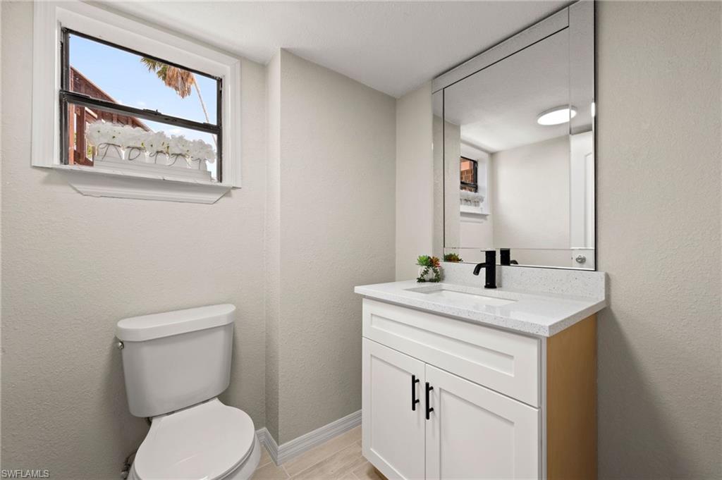 17397 Lee Road Fort Myers, FL 33967 - Photo 7 of 22 a bathroom with a toilet a sink and mirror