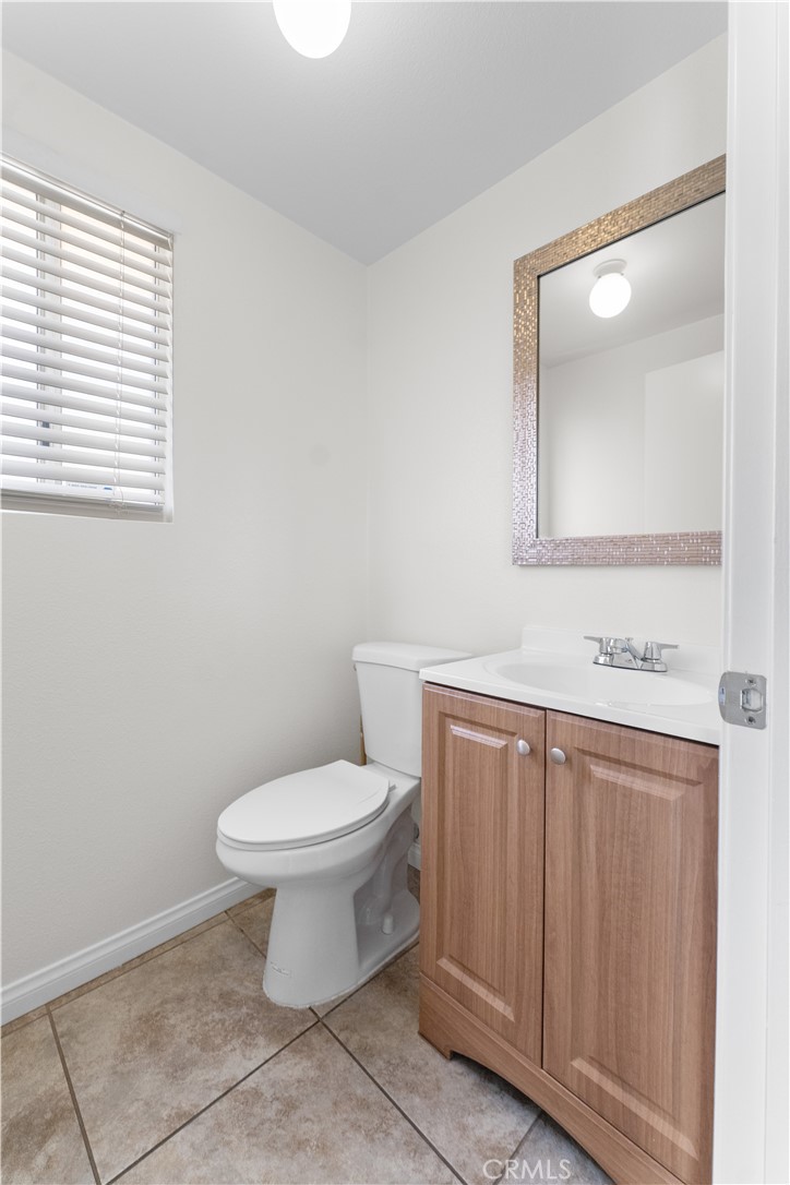 1232 Kings Road Palmdale, CA 93551 - Photo 16 of 32 a bathroom with a toilet sink and mirror