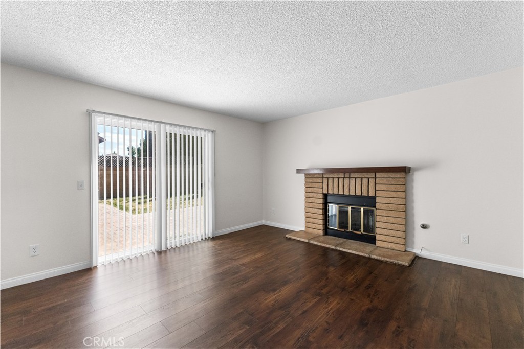 1232 Kings Road Palmdale, CA 93551 - Photo 17 of 32 an empty room with wooden floor fireplace and windows