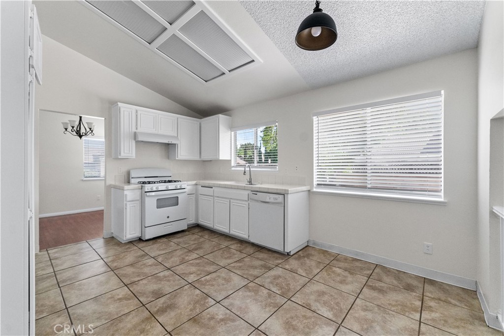 1232 Kings Road Palmdale, CA 93551 - Photo 19 of 32 a kitchen with a stove a sink and cabinets