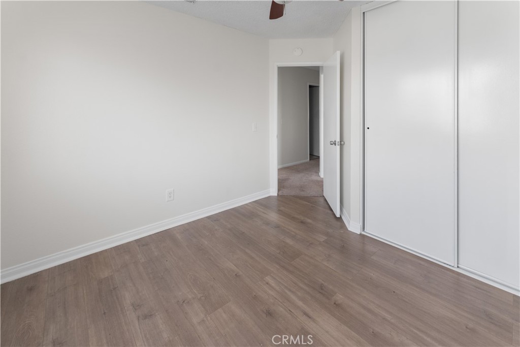 1232 Kings Road Palmdale, CA 93551 - Photo 2 of 32 wooden floor in a hall with an empty room