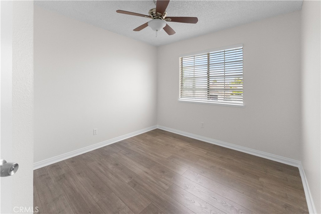 1232 Kings Road Palmdale, CA 93551 - Photo 3 of 32 an empty room with wooden floor fan and windows