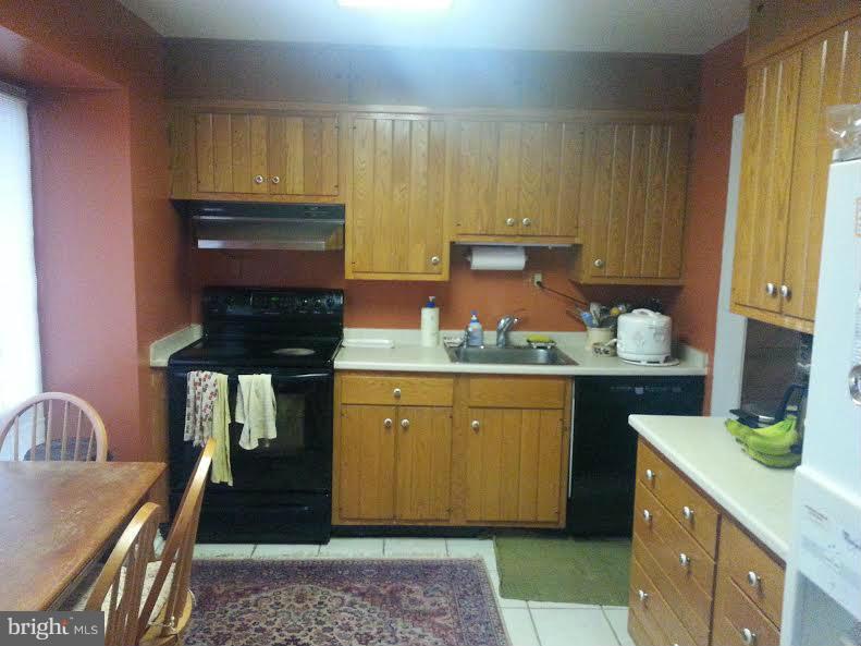 6309 Charnwood Street Springfield, VA 22152 - Photo 4 of 4 a kitchen with a sink stove and cabinets