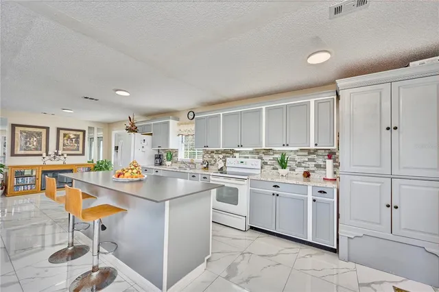 a kitchen with a sink and chairs