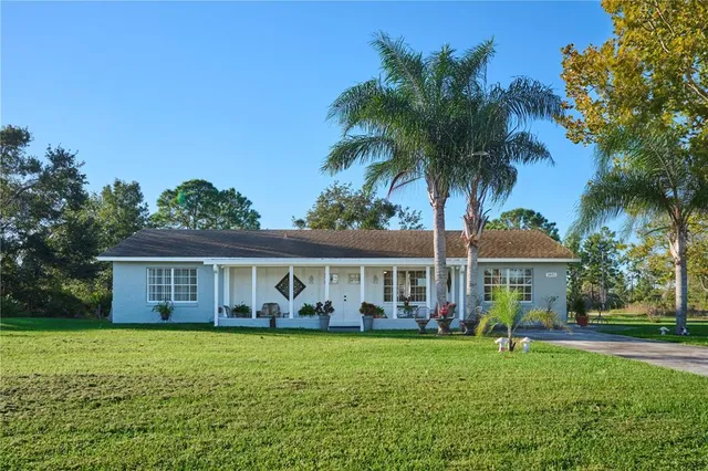 a view of house with yard and outdoor seating