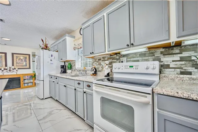 a kitchen with stainless steel appliances granite countertop a sink and dishwasher a stove with wooden cabinets