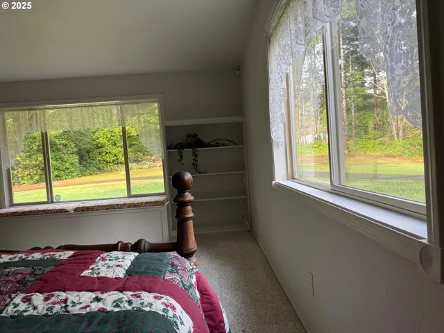 a bedroom with a bed and a large window