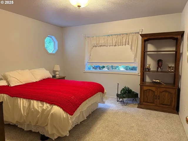 a bed sitting in a bedroom next to a window