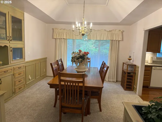 a dining room with furniture a chandelier and window