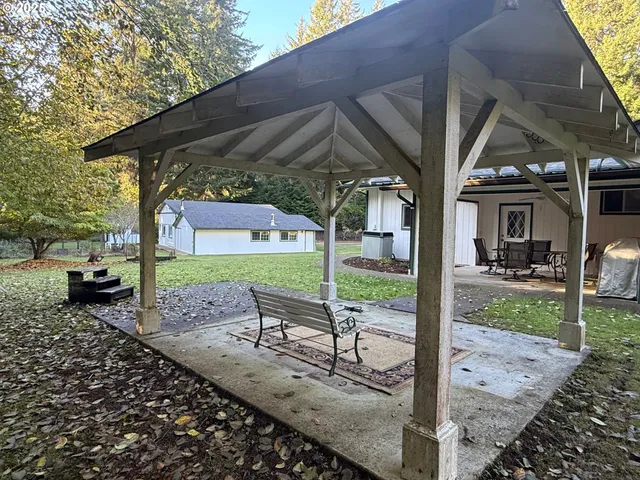 a view of a porch with a table and chairs under an umbrella