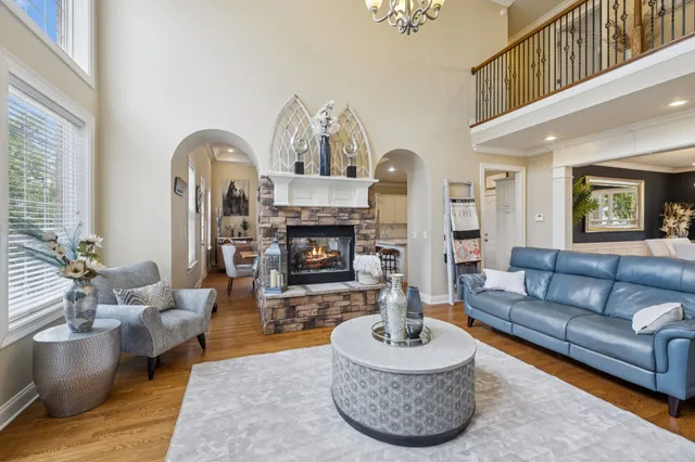 a living room with furniture a fireplace and a large window