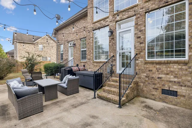 a view of a patio with couches and table and chairs next to a yard
