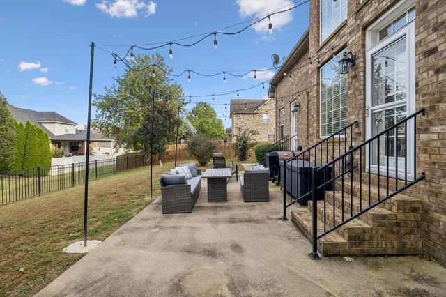 a patio with a table and chairs and potted plants