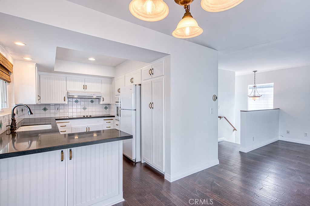 2712 Shell Street Corona del Mar, CA 92625 - Photo 6 of 18 a kitchen with stainless steel appliances granite countertop a refrigerator a sink dishwasher a stove and white cabinets with wooden floor