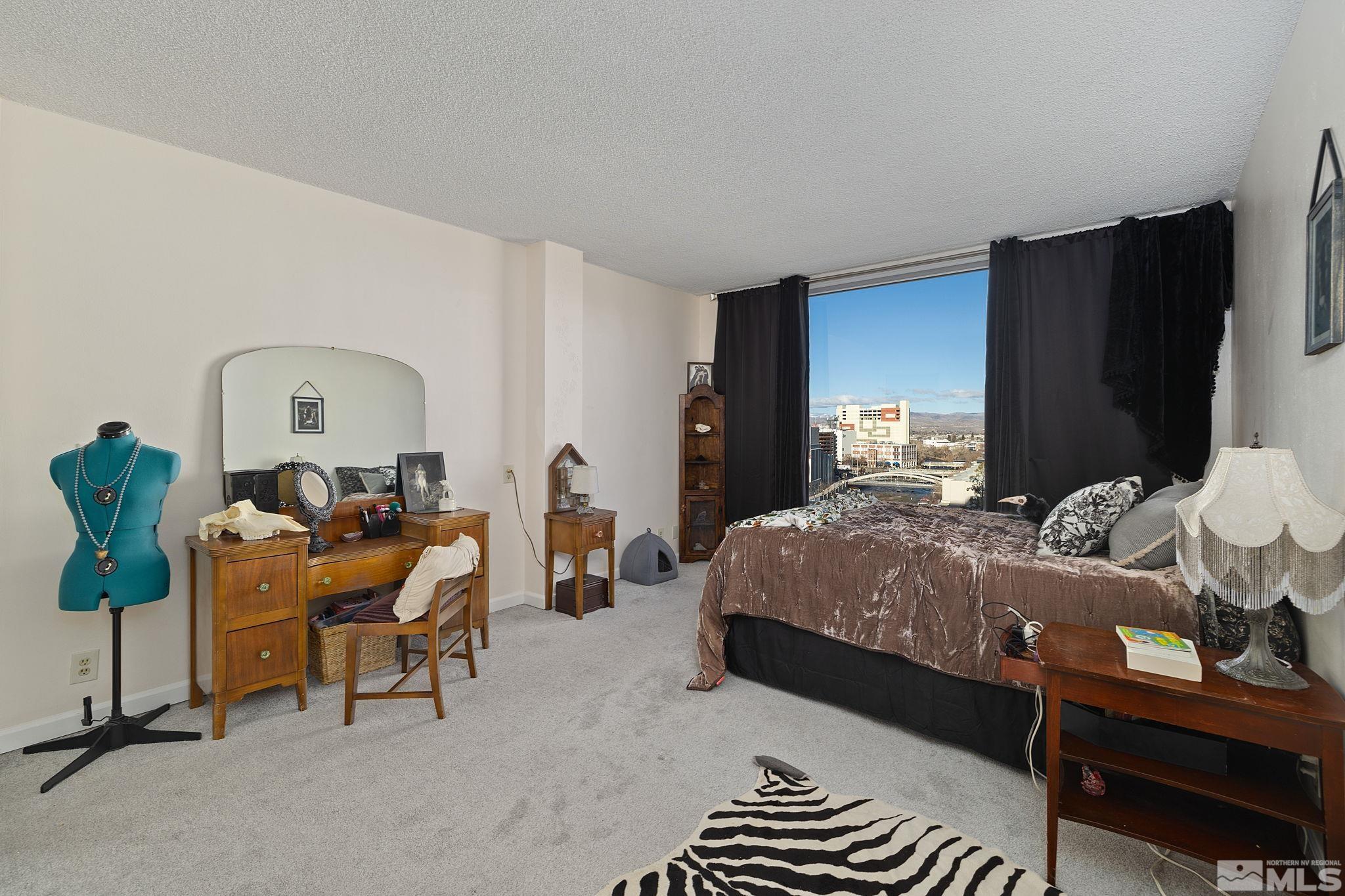 280 Island Avenue, Unit 1105 Reno, NV 89501 - Photo 11 of 17 a bedroom with a bed and a chandelier