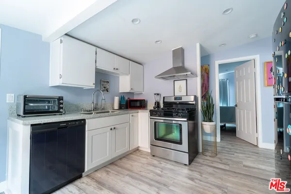 a kitchen with stainless steel appliances granite countertop a refrigerator and a stove top oven