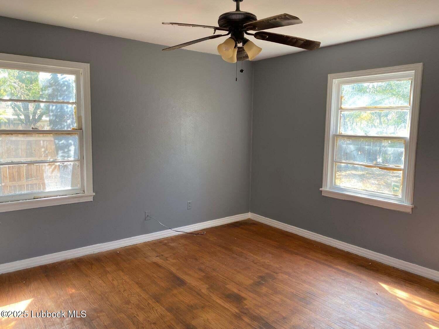 1917 39th Street Lubbock, TX 79412 - Photo 6 of 7 an empty room with a window and a fan