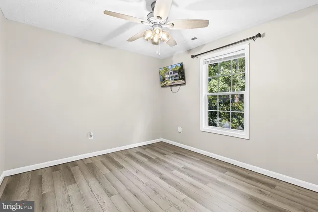 an empty room with a window and a fan